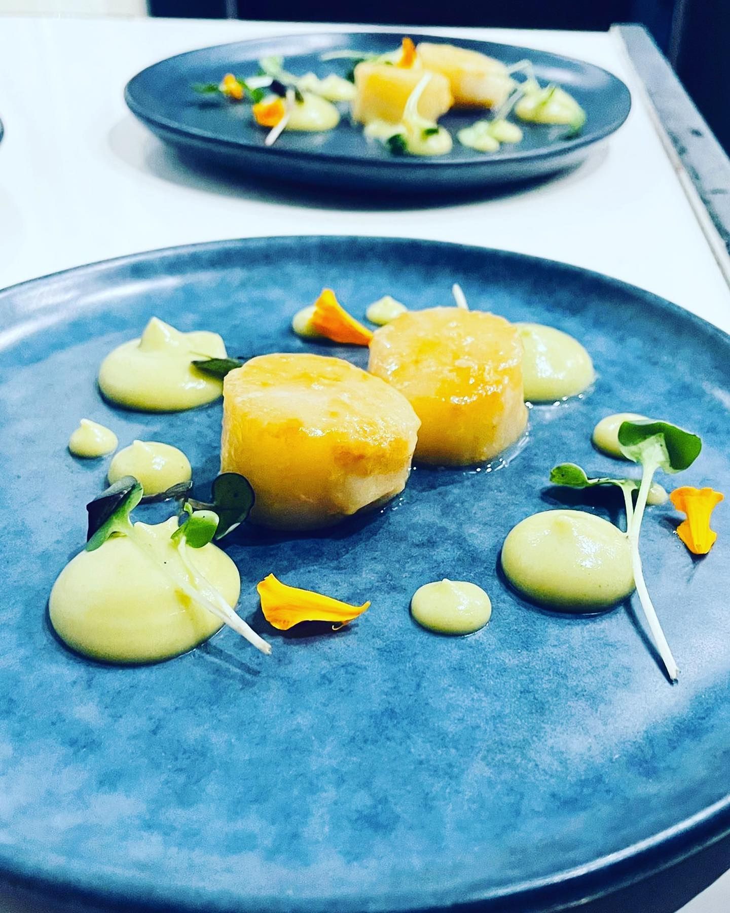 Dos platos de comida en una mesa con un plato azul en primer plano.