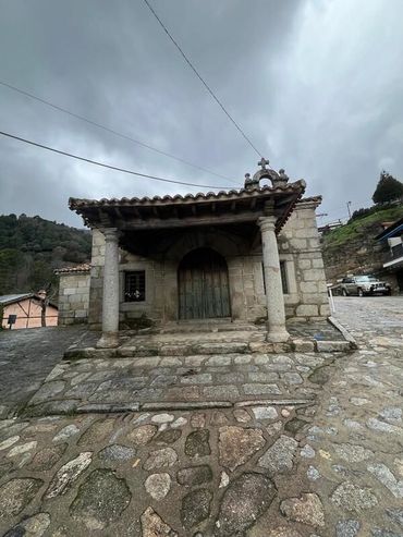 Un camino de piedra conduce a un edificio con una puerta de madera.