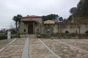 Un camino de piedra conduce a un edificio con una puerta de madera.