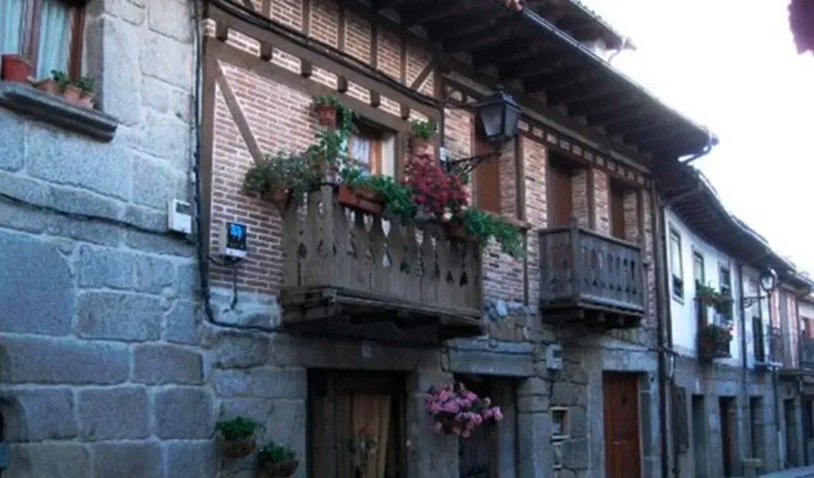 Un edificio con un balcón y flores.
