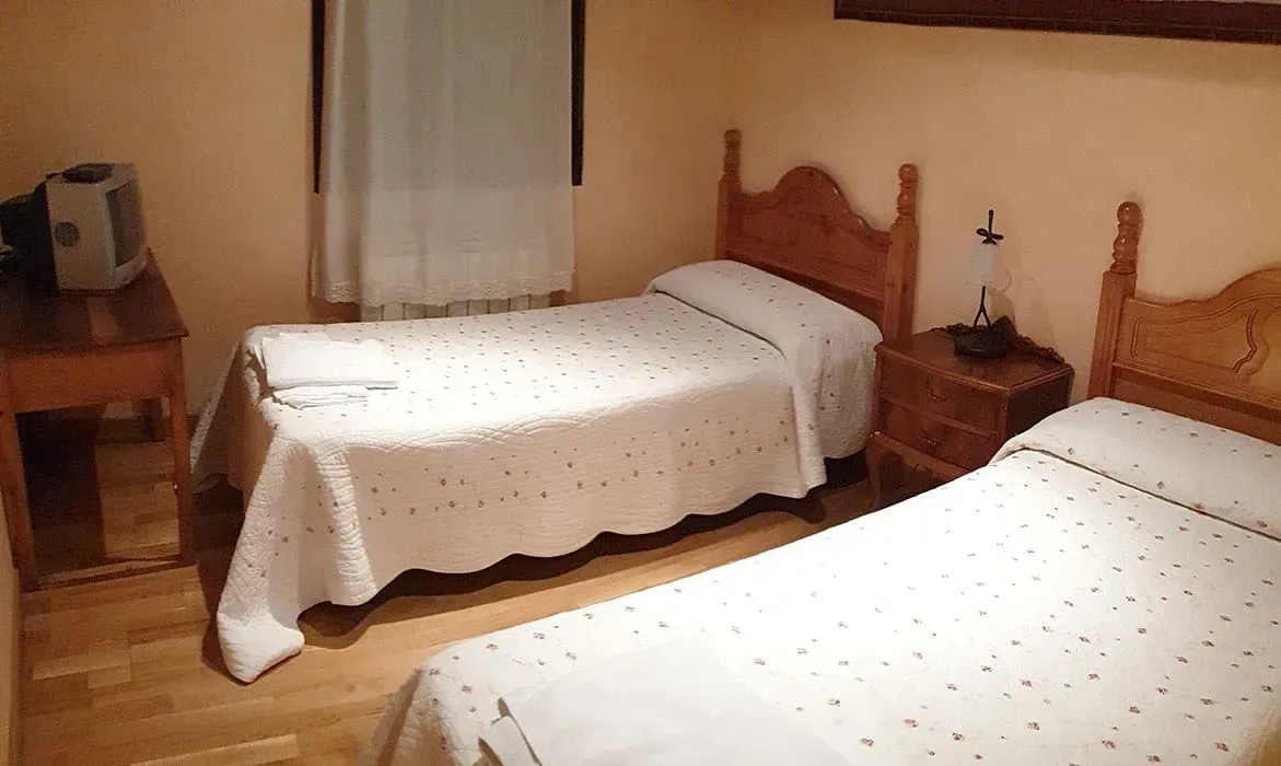 Un dormitorio con dos camas individuales y una mesita de noche.