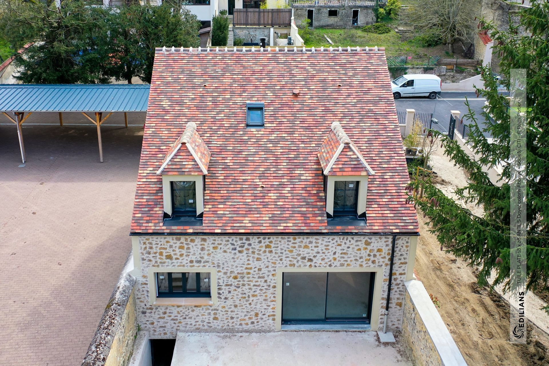 Maison avec une baie vitrée, trois fenêtres et une fenêtre de toit