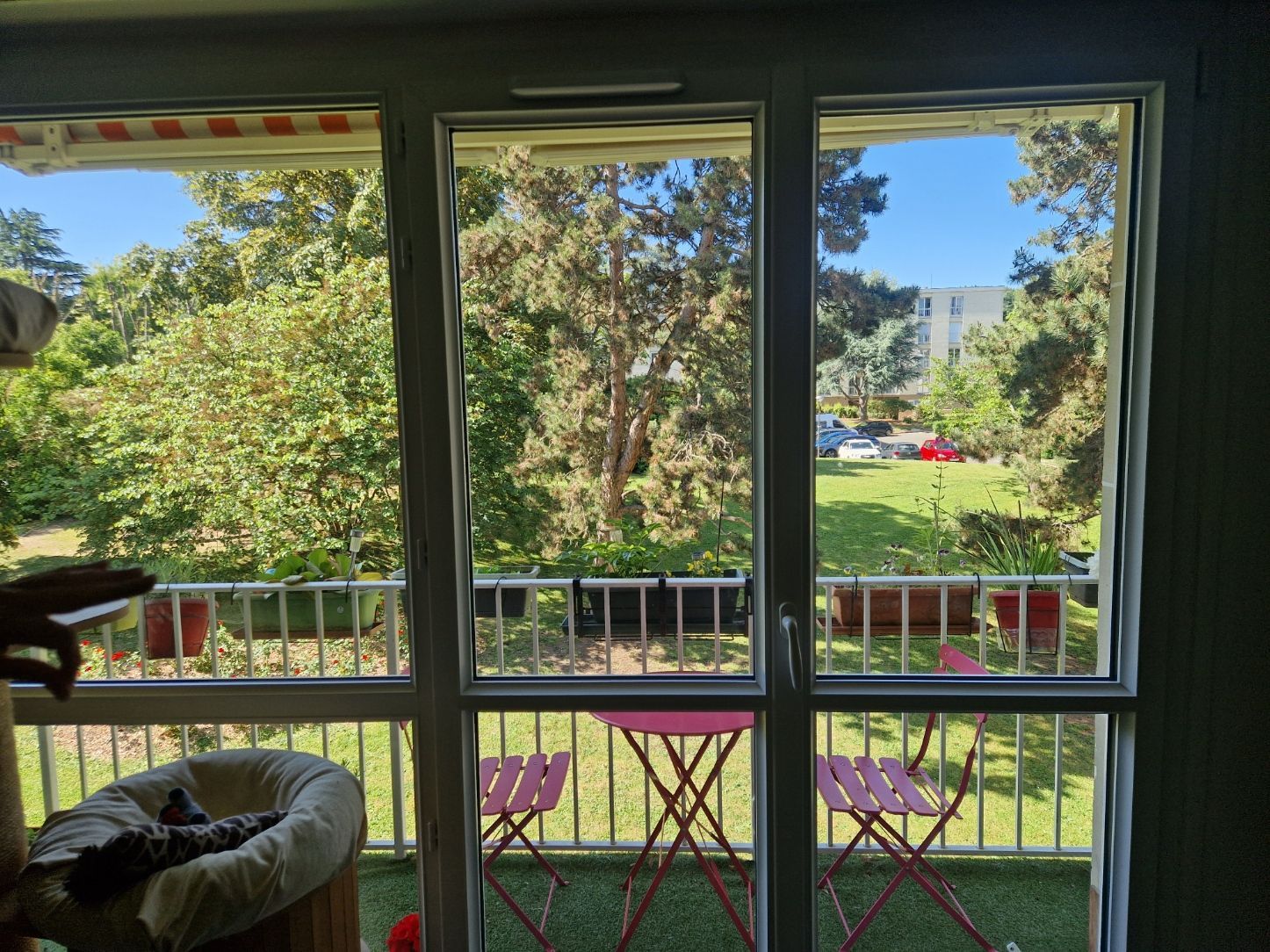 Baie vitrée donnant sur un balcon terrasse avec une table et des chaises