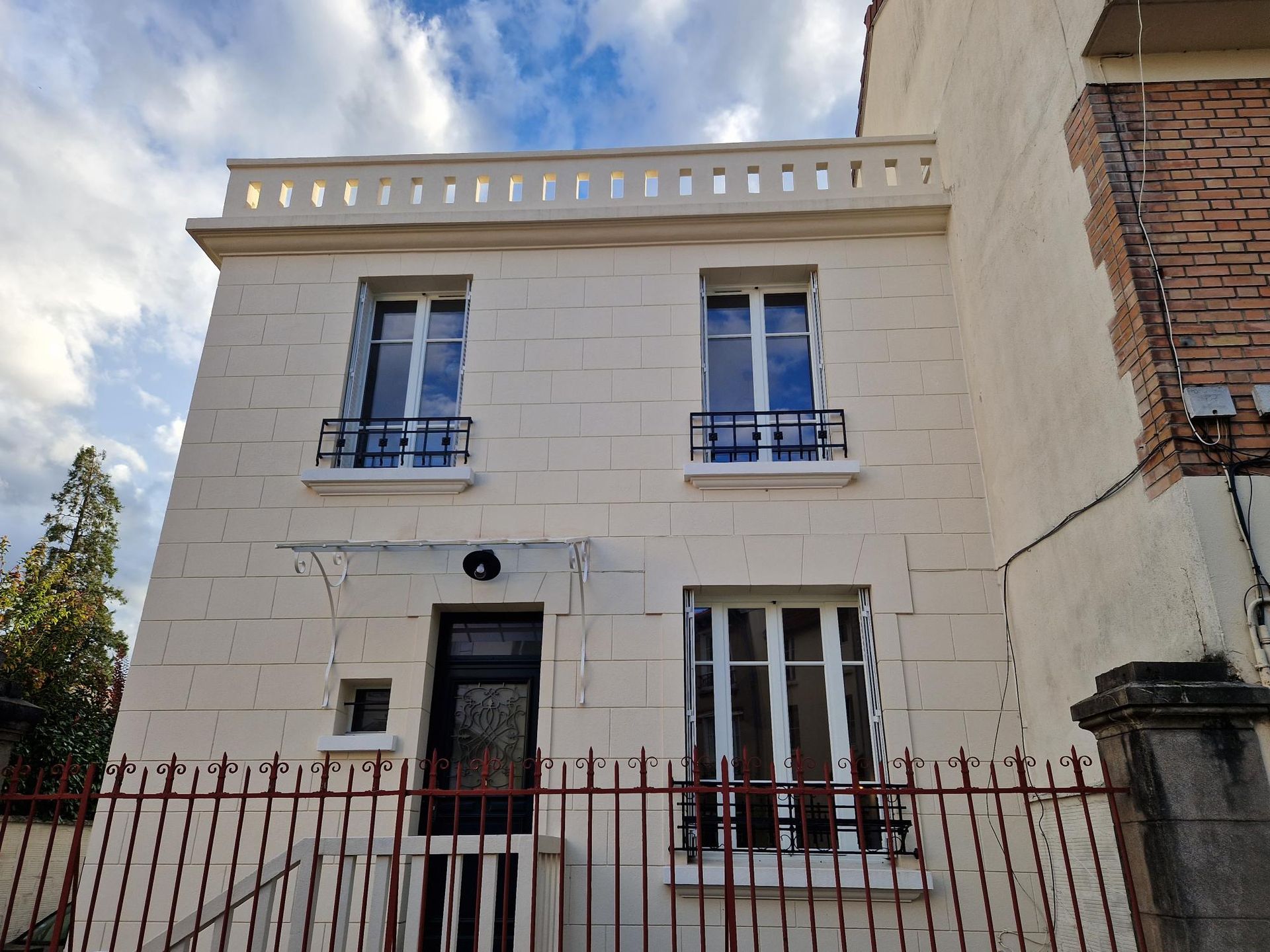 façade d'un bâtiment avec  3 fenêtres et une porte d'entrée