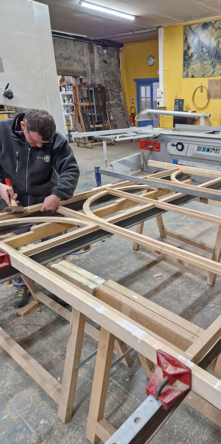 Professionnel de la menuiserie utilisant un marteau sur une pièce en bois