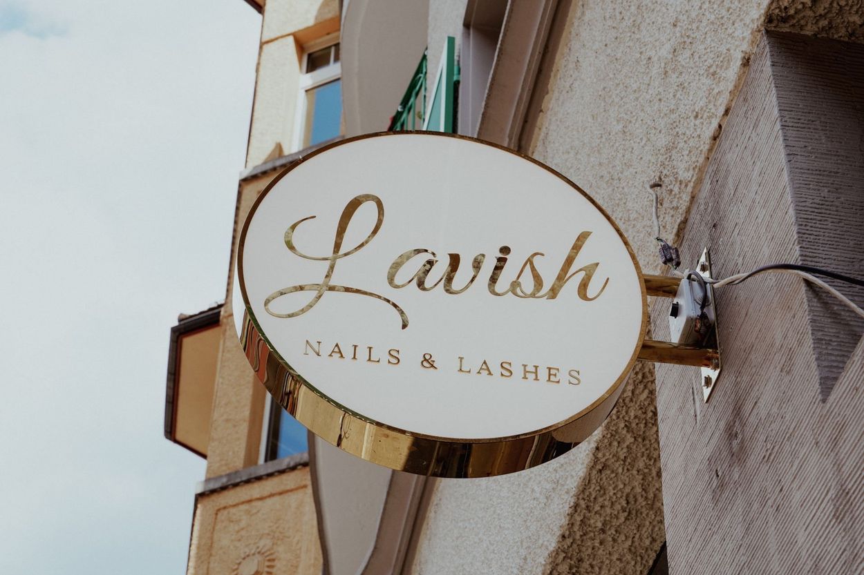 Ein Schild für aufwendige Nägel und Wimpern hängt an der Seite eines Gebäudes, Lavish Nails & Lashes