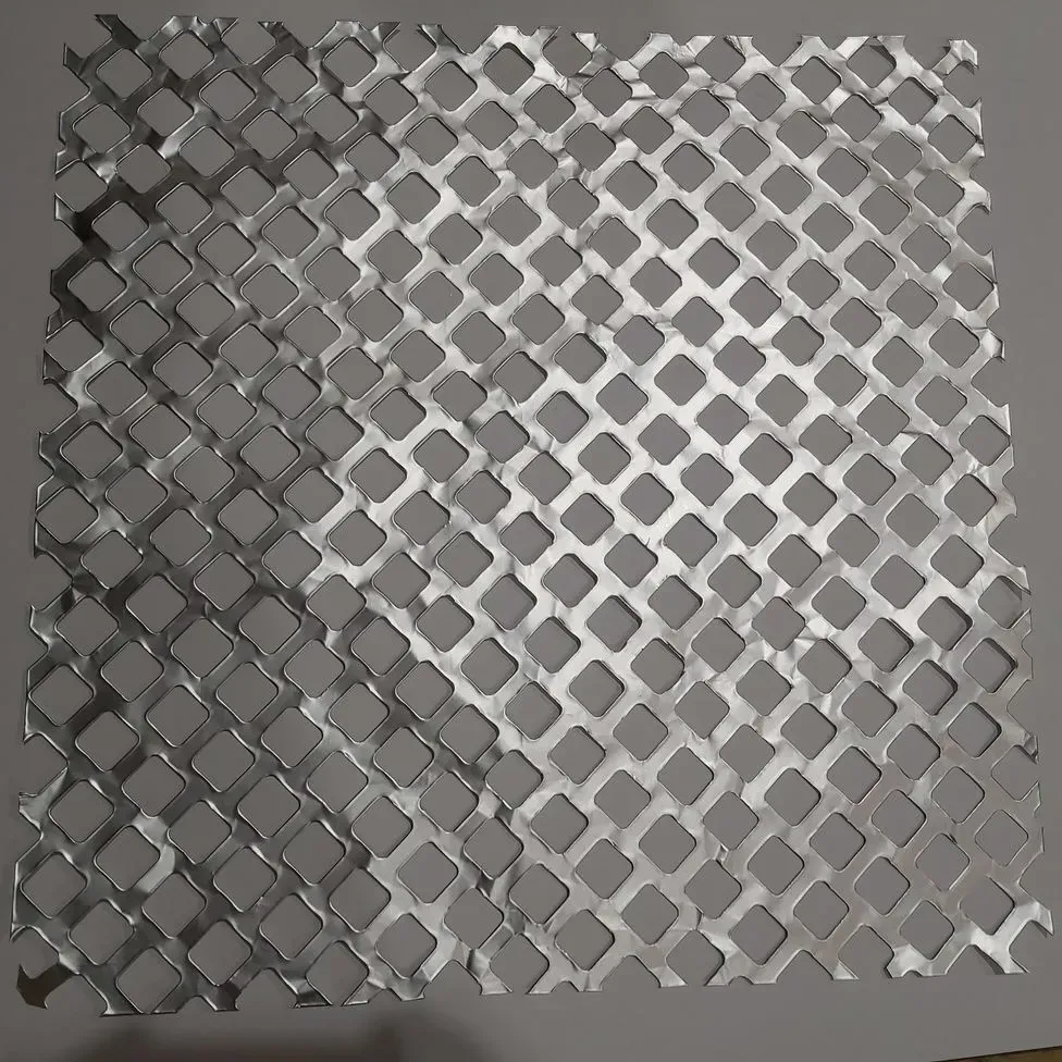 Un trozo de metal con agujeros está sobre una mesa.