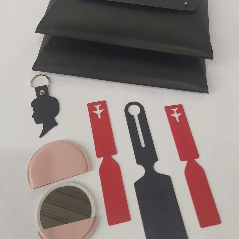 Una silueta de una mujer está en un llavero al lado de un bolso.