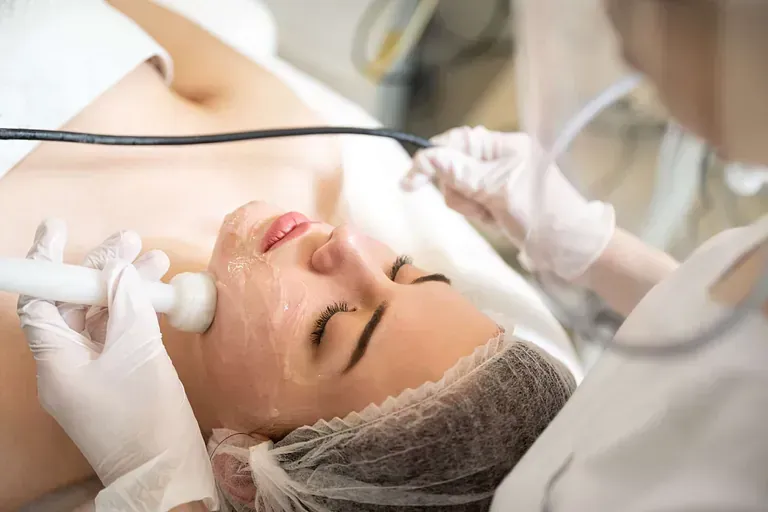 Una mujer está recibiendo un tratamiento facial en un salón de belleza.