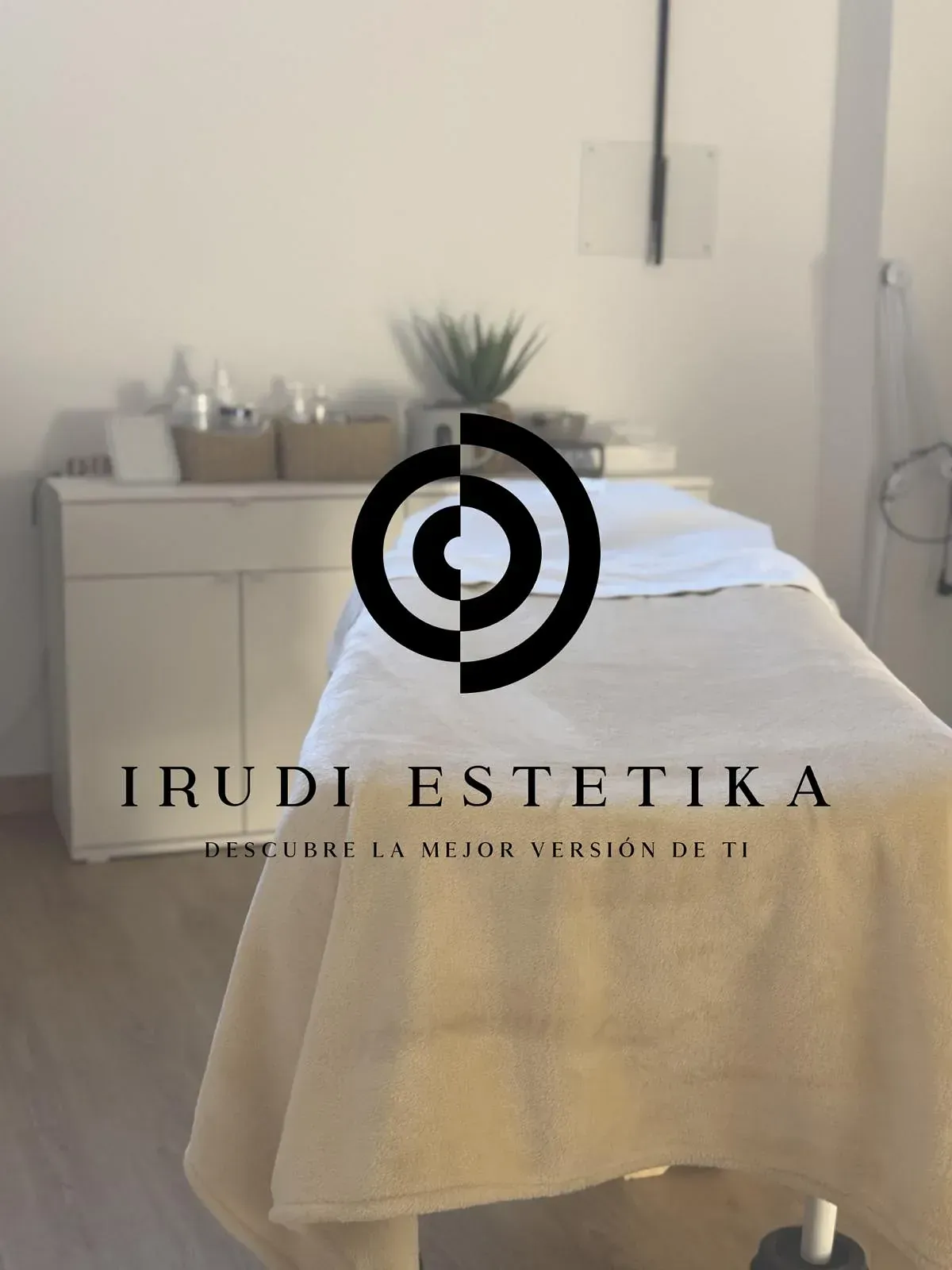 Una mesa de masajes con el logotipo de Irudi Estetica.