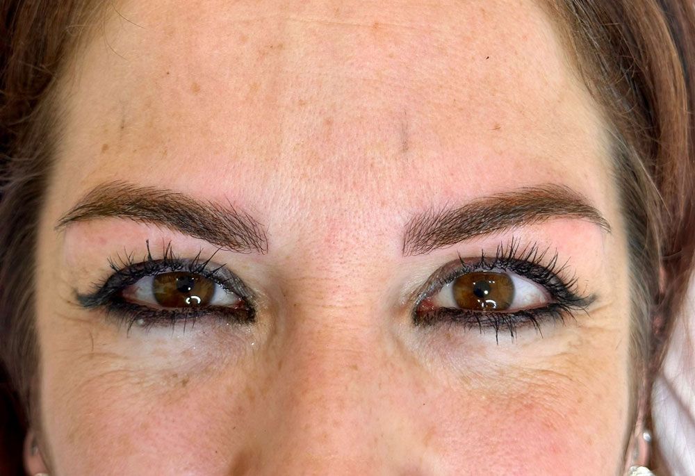 Un primer plano del rostro de una mujer con ojos y cejas marrones.