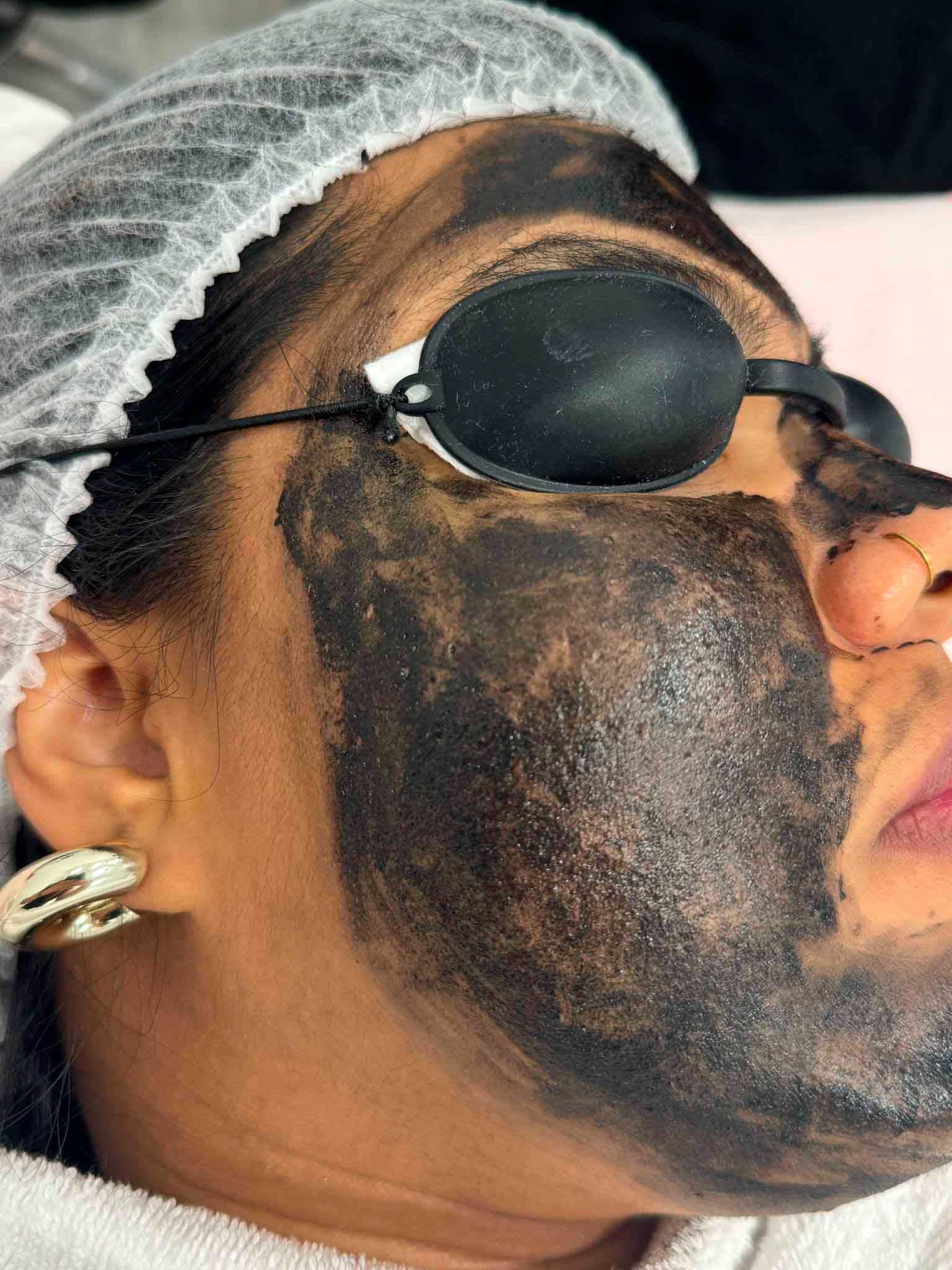 Una mujer con una máscara negra en la cara lleva gafas de sol.