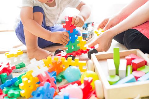 Kinder spielen mit bunten Bausteinen auf dem Boden