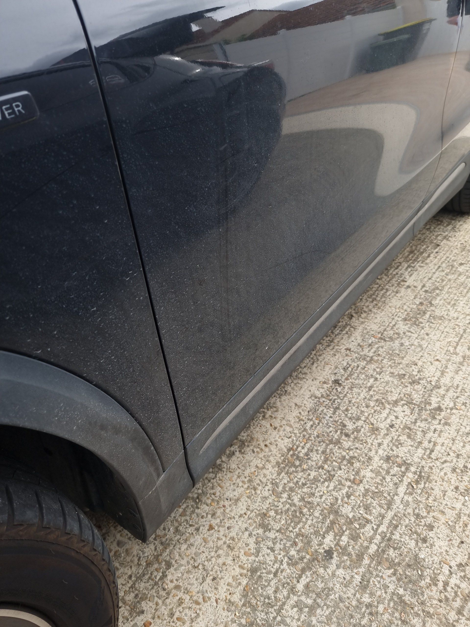 Détail de l'aile d'une voiture noire avant le nettoyage
