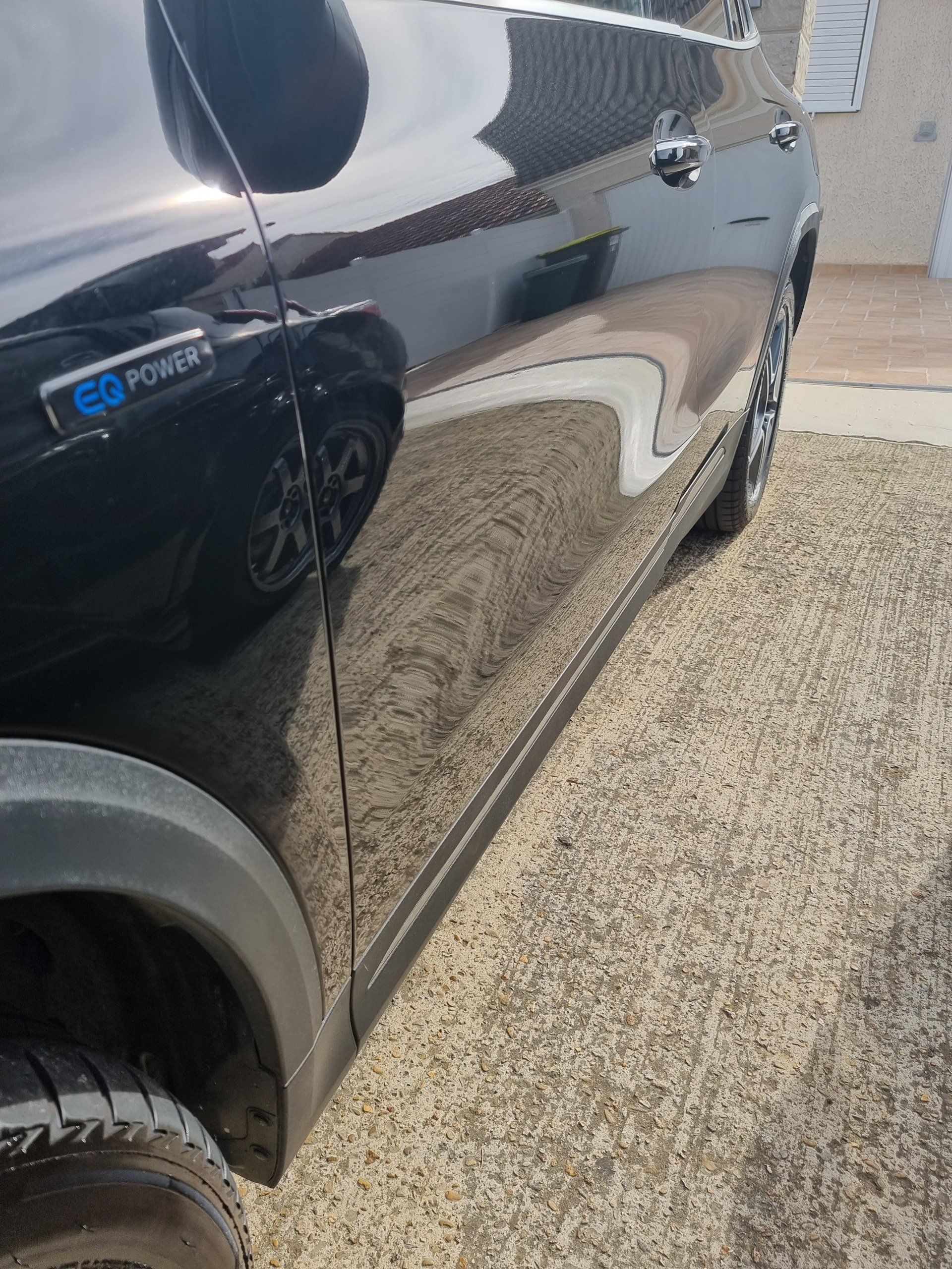 Détail de l'aile d'une voiture noire après le nettoyage