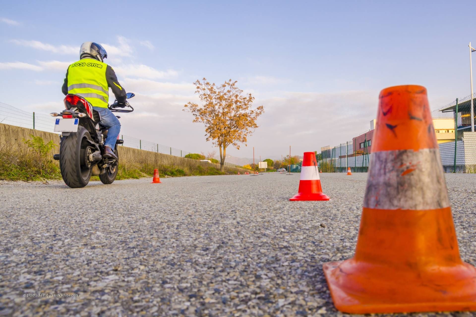 Motorradfahrer mit gelber Warnweste auf einem Verkehrsübungsplatz