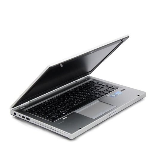 Ordinateur portable argenté avec clavier noir, partiellement ouvert sur fond blanc
