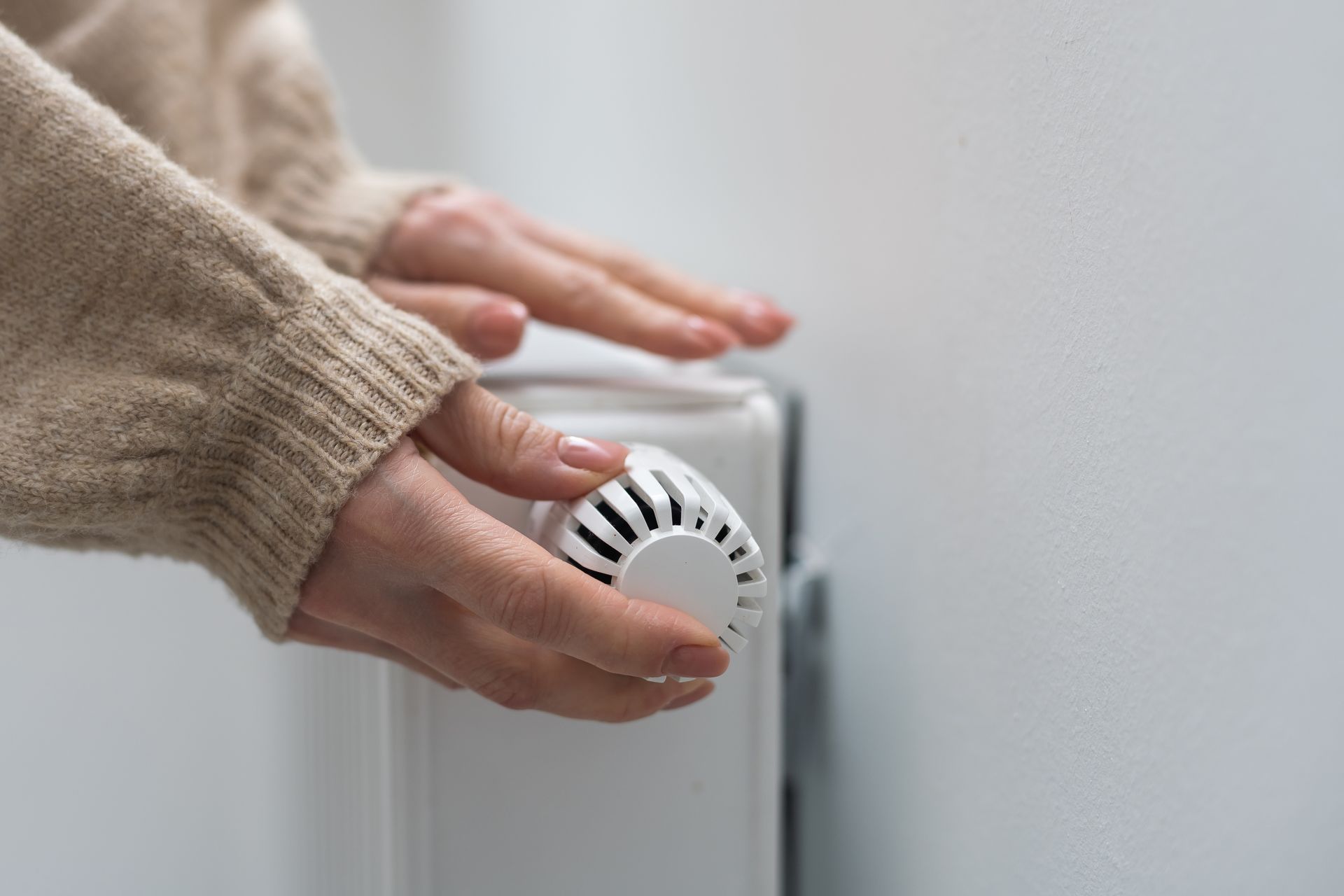 Une main qui contrôle un chauffage