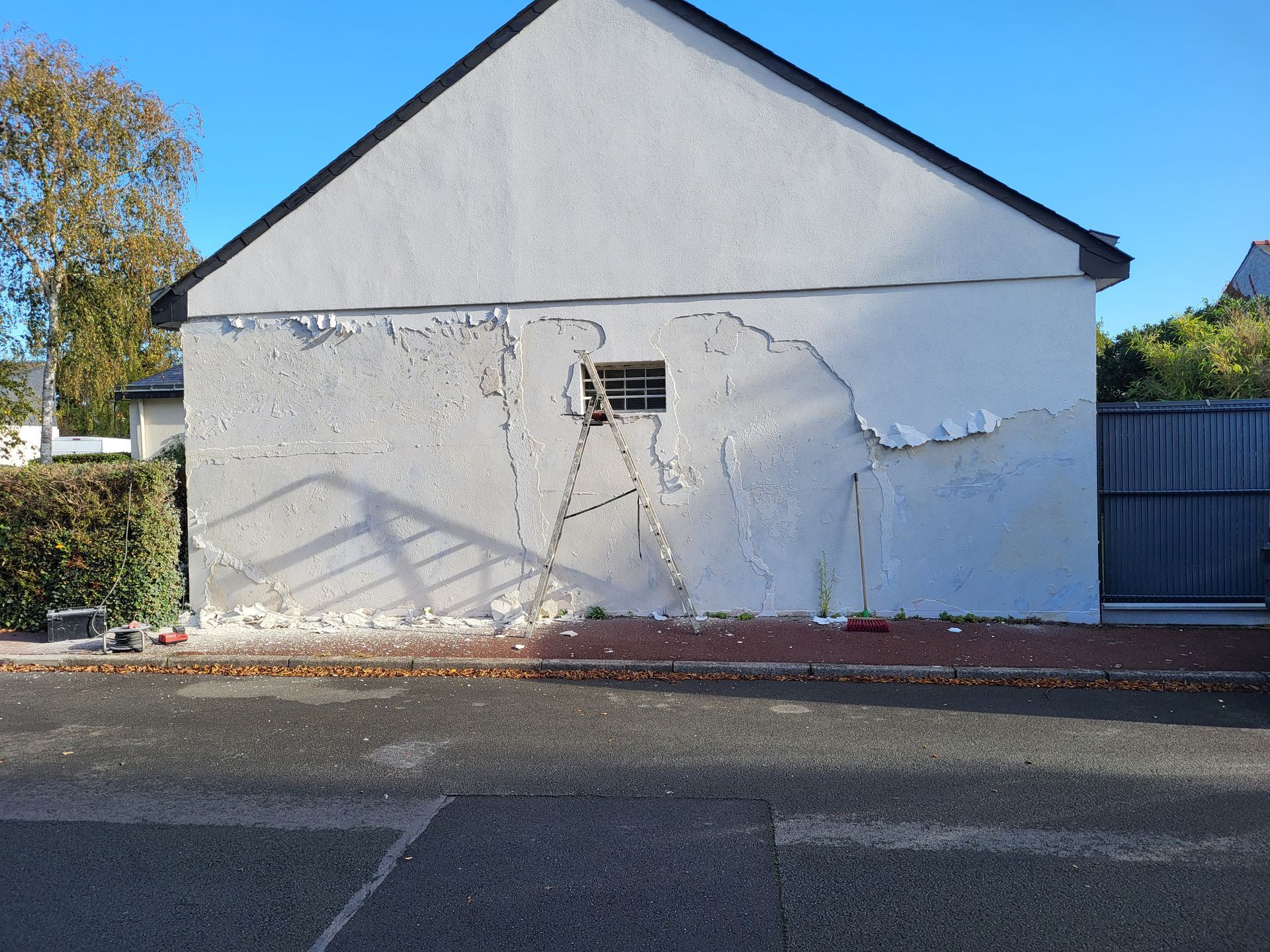 Façade d'une maison, avec une petite fenêtre, abîmée.