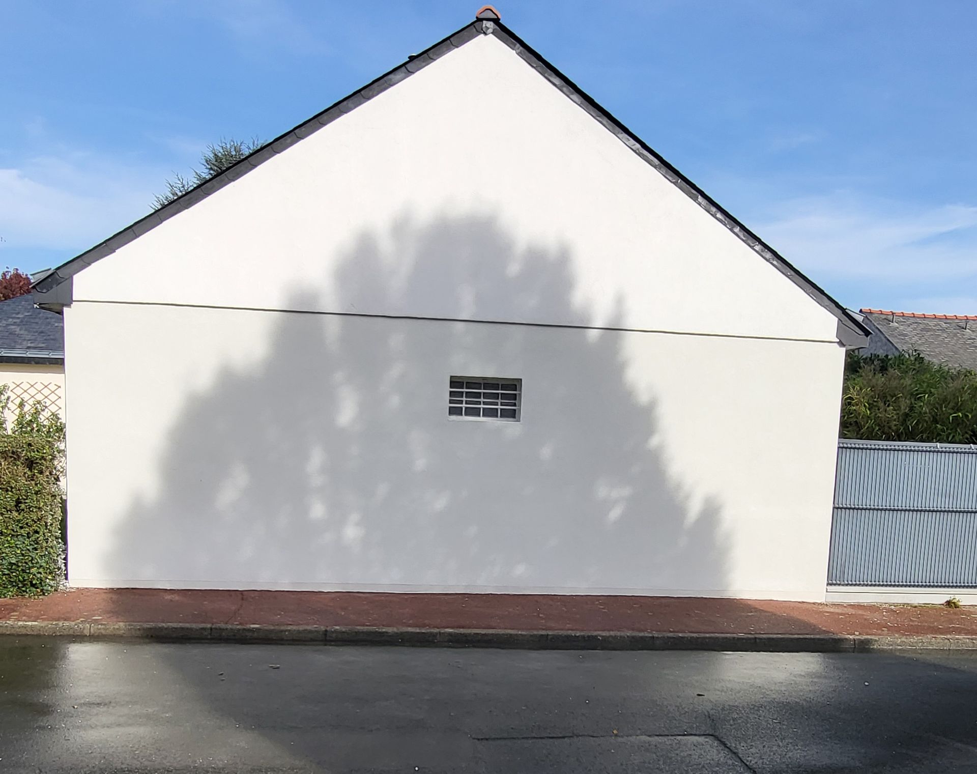 Façade d'une maison, avec une petite fenêtre, rénovée.