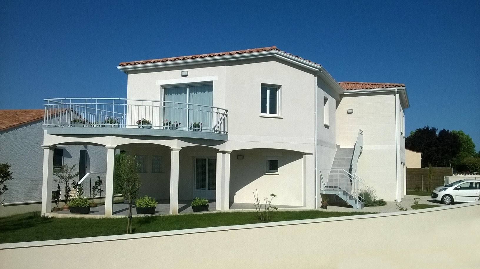 Maison à étage claire avec balcon et porche couvert.
