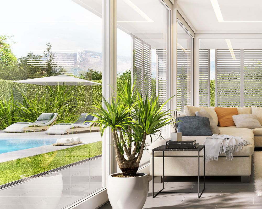 Salon lumineux avec vue sur la piscine.