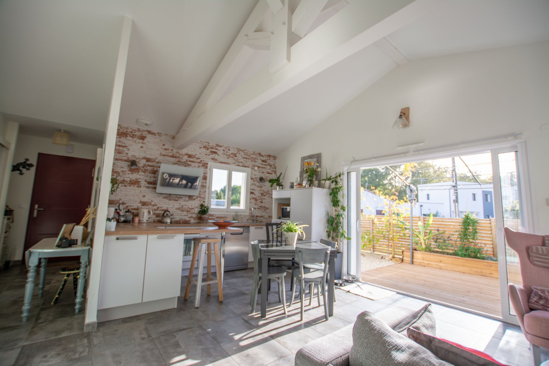 Cuisine et séjour lumineux, avec un mur en briques.