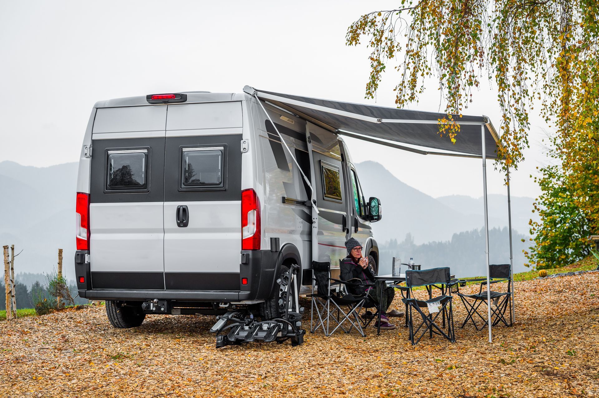 Van avec un store banne en automne