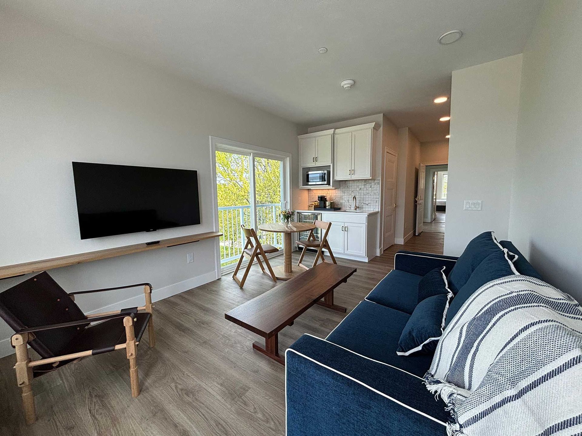 Room with a couch, tv, and table and chairs.