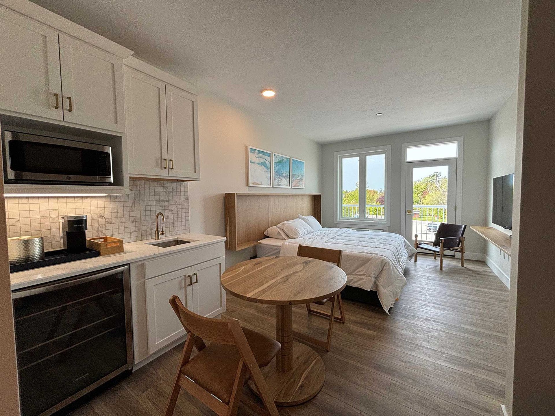 Suite with king bed, table and chairs, and kitchenette.