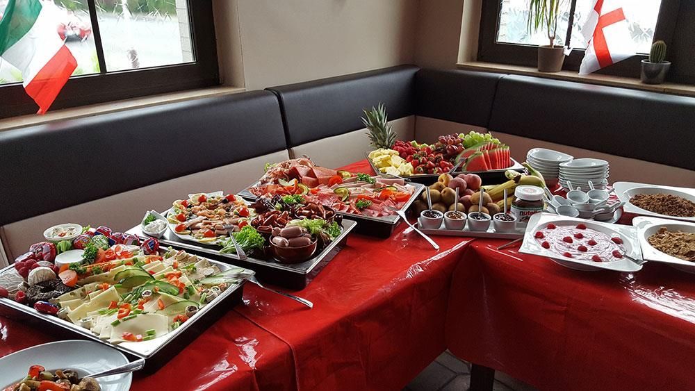 Ein Tisch mit Tellern voller Essen darauf und ein Fenster im Hintergrund.