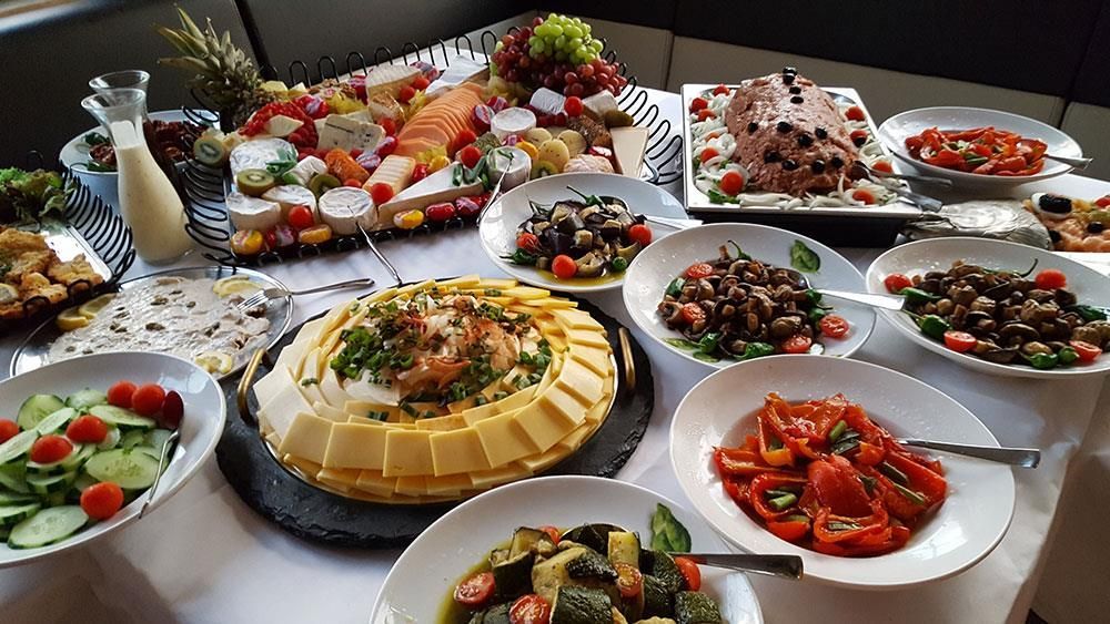 Es kommen viele unterschiedliche Speisen auf den Tisch.