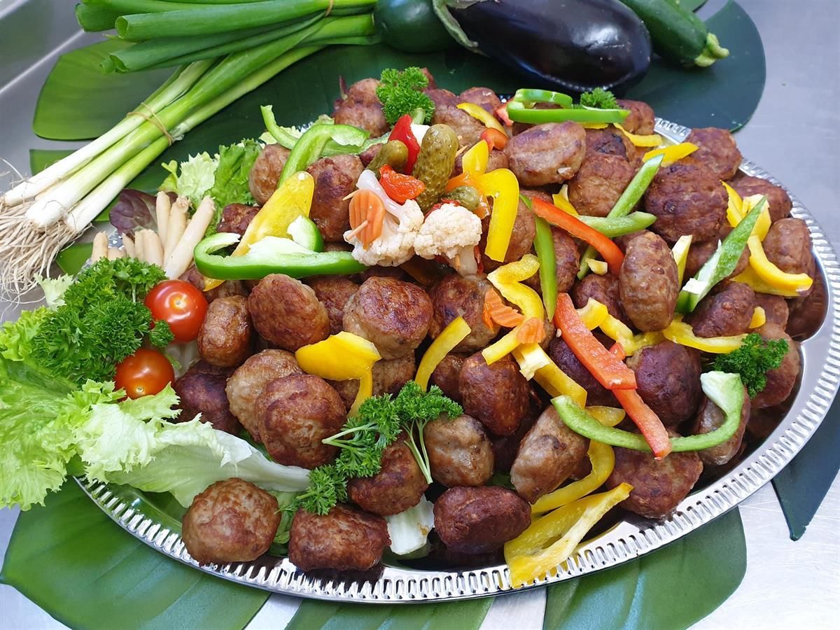 Ein Teller mit Fleischbällchen und Gemüse auf einem Tisch
