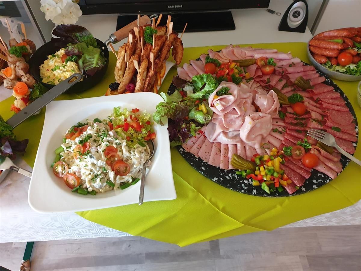 Ein Tisch mit Tellern voller Essen und einer Schüssel Salat.