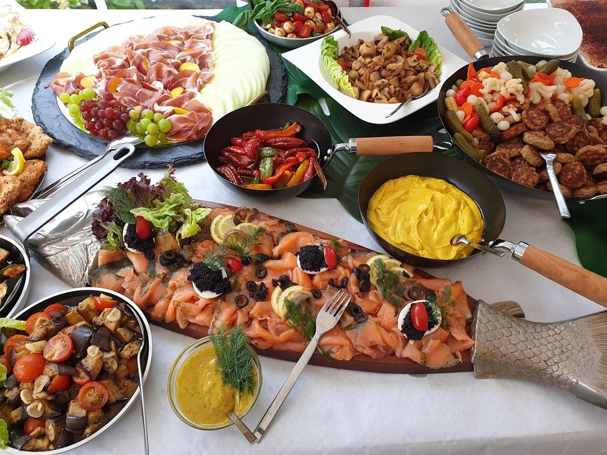 Ein Tisch mit einer Auswahl an Speisen, darunter geräucherter Lachs