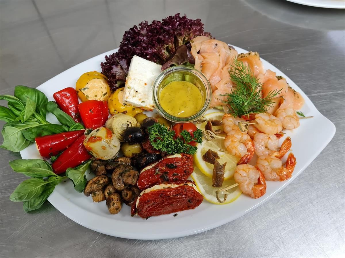 Ein Teller mit Garnelen und Gemüse auf einem Tisch.