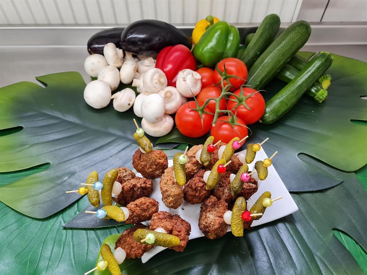 Ein Teller mit Essen, eingelegtem Gemüse und Gemüse auf einem Tisch.