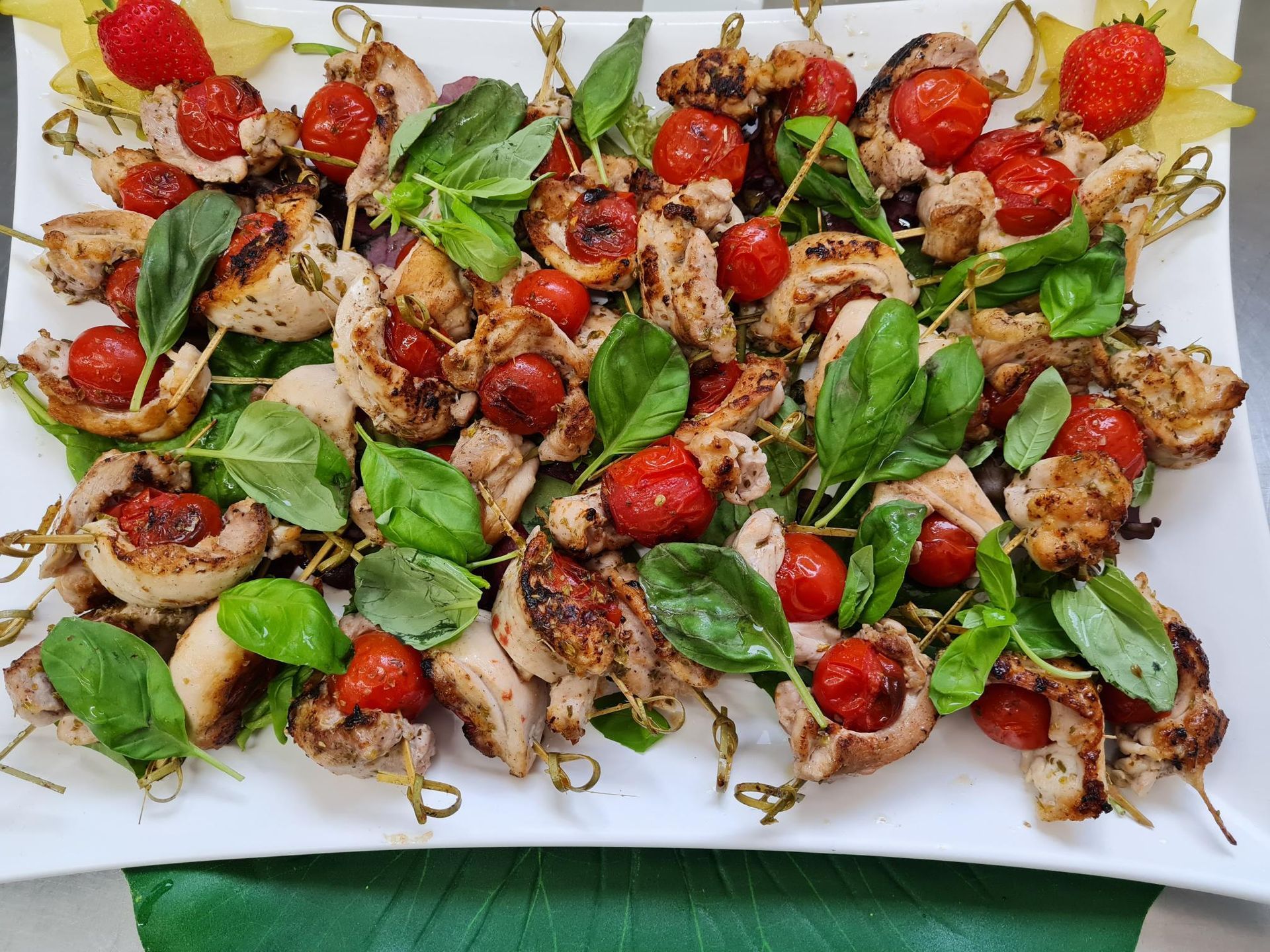 Ein Teller mit Essen mit Tomaten und Mozzarella auf Zahnstochern