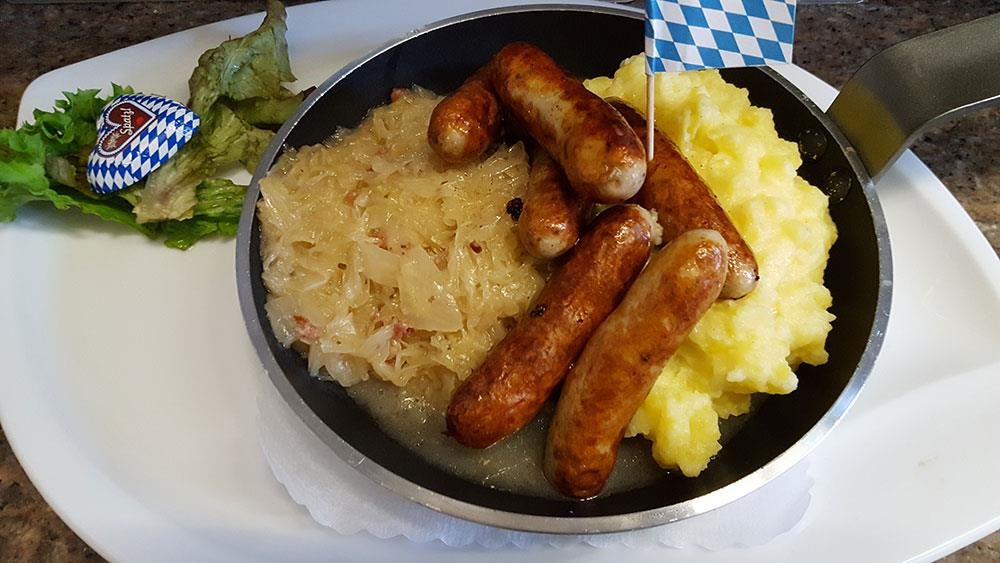Eine Bratpfanne gefüllt mit Würstchen und Kartoffelbrei