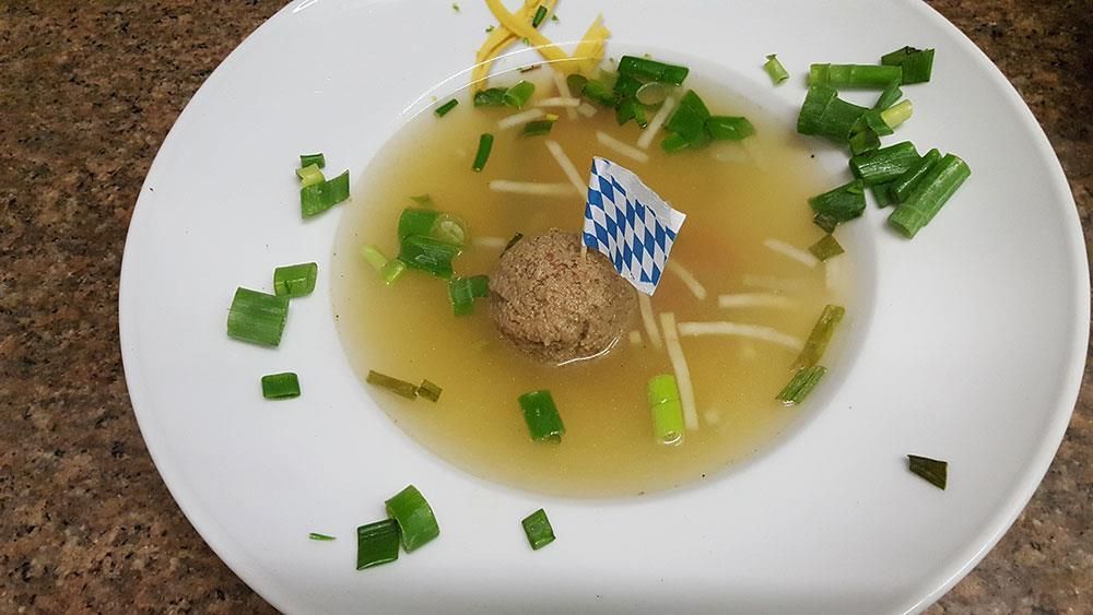 Eine Schüssel Suppe mit Nudeln und Frühlingszwiebeln auf einem Tisch