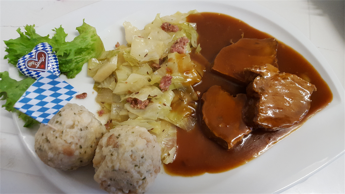 Ein weißer Teller mit Fleischsauce und Kartoffeln