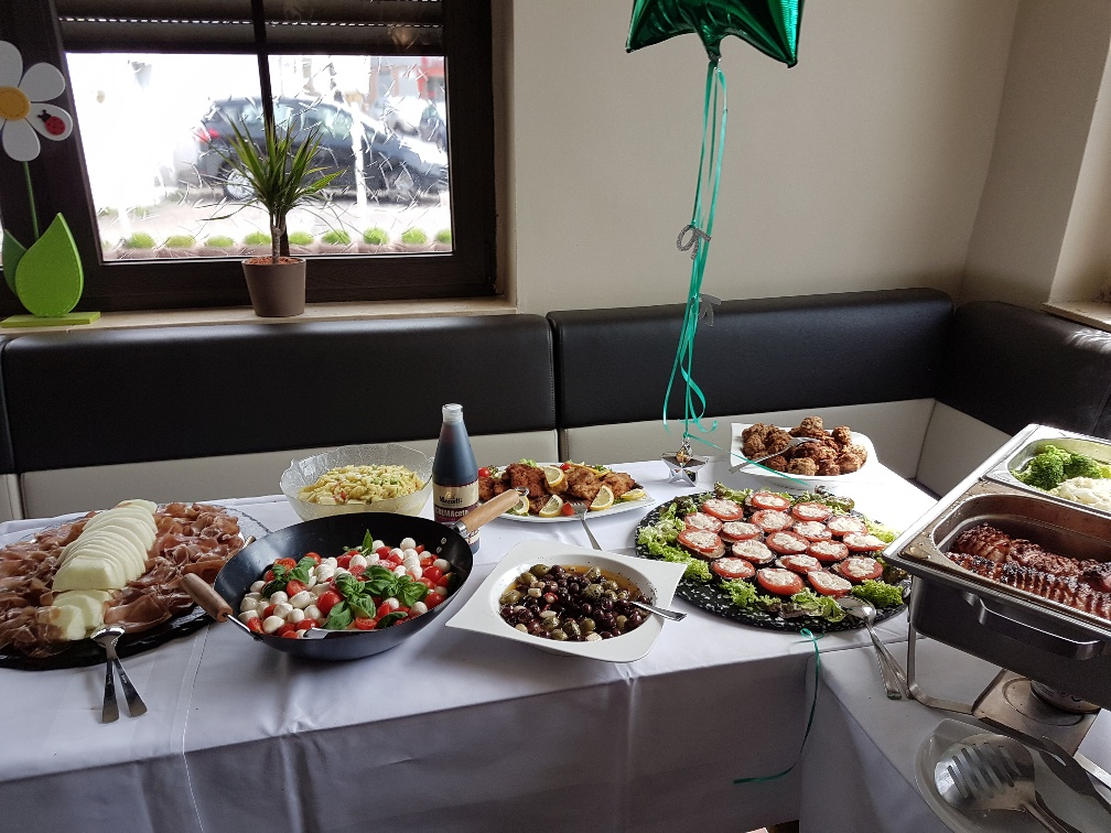 Ein Tisch mit Tellern voller Essen und einem grünen Ballon darauf
