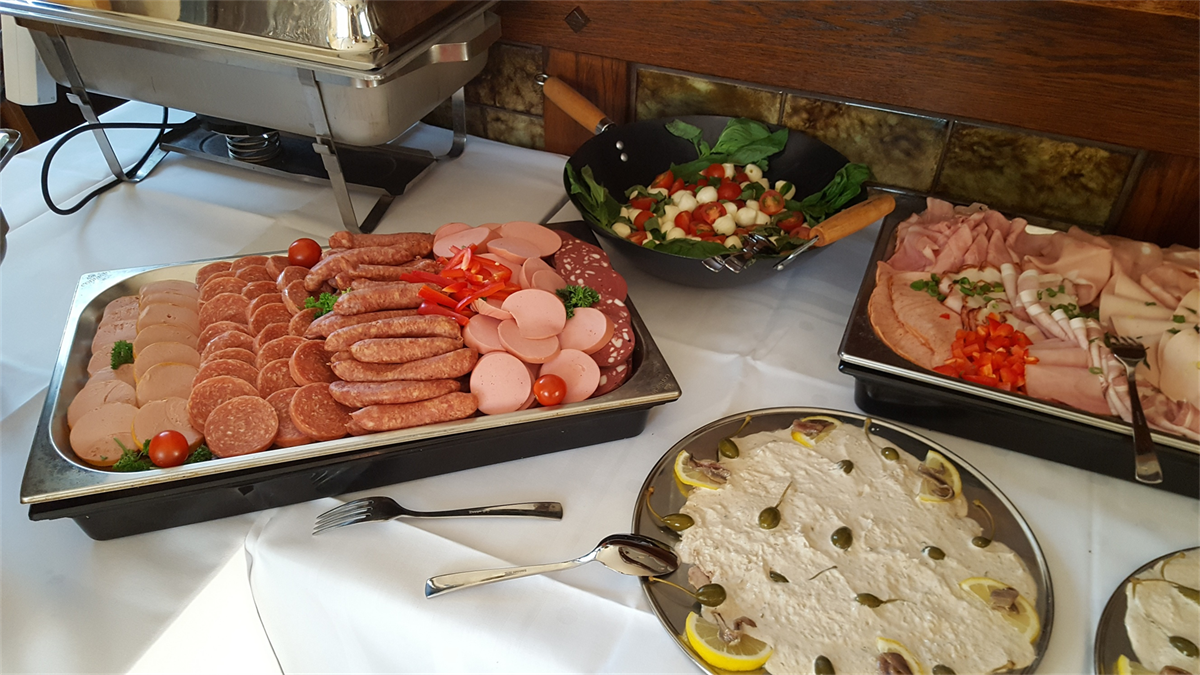Ein Buffet-Tisch mit einer Auswahl an Fleisch und Salaten.
