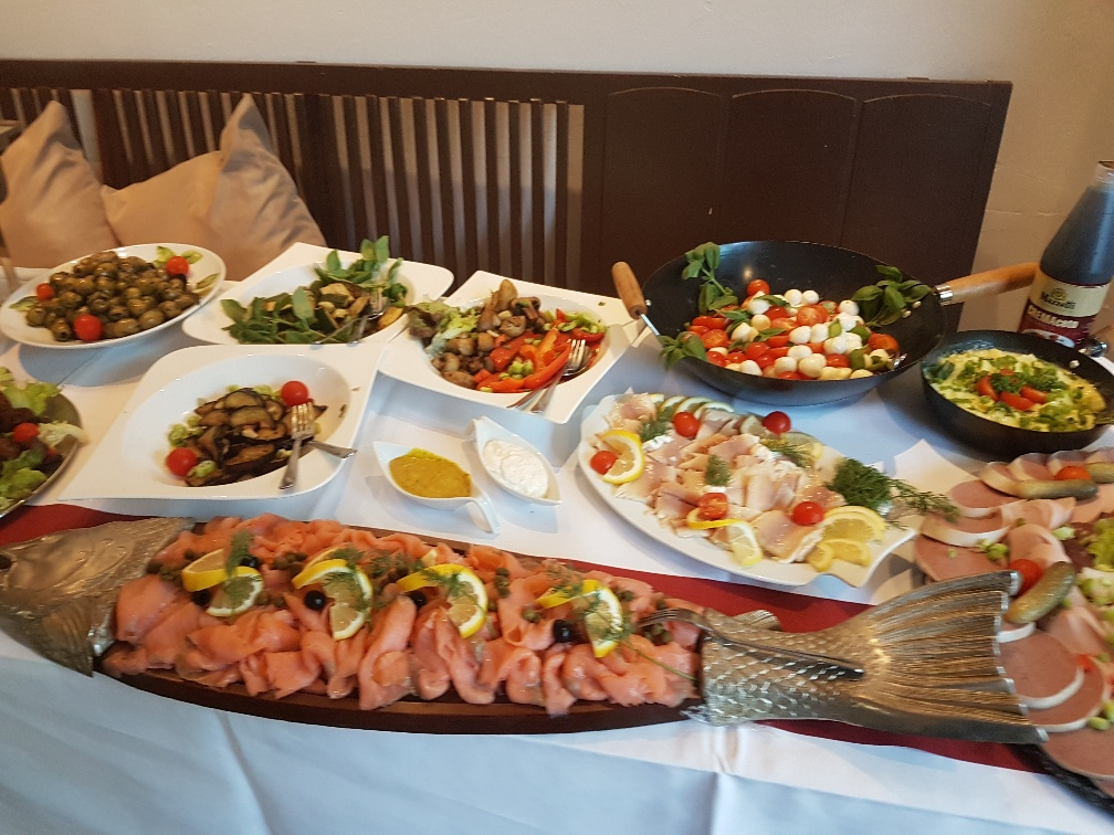 Ein Tisch mit Tellern voller Essen, darunter ein großer Fisch