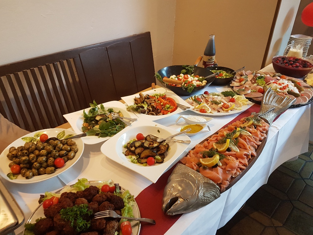 Ein Tisch mit Tellern voller Essen und einem Fisch darauf