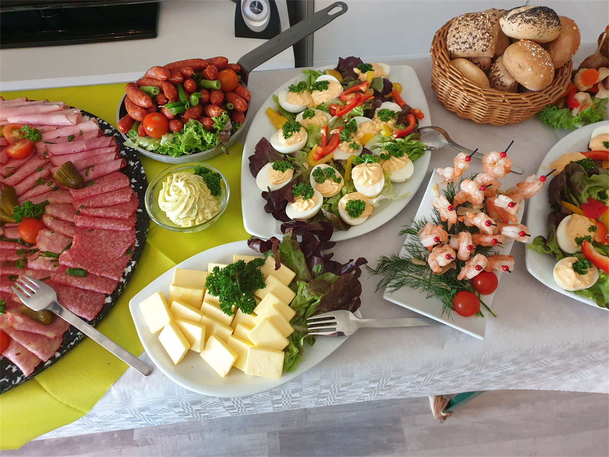 Ein Tisch mit Tellern voller Essen, darunter Garnelen und Käse