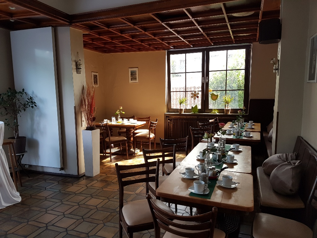 Ein Esszimmer mit Tischen und Stühlen und einem Fenster.