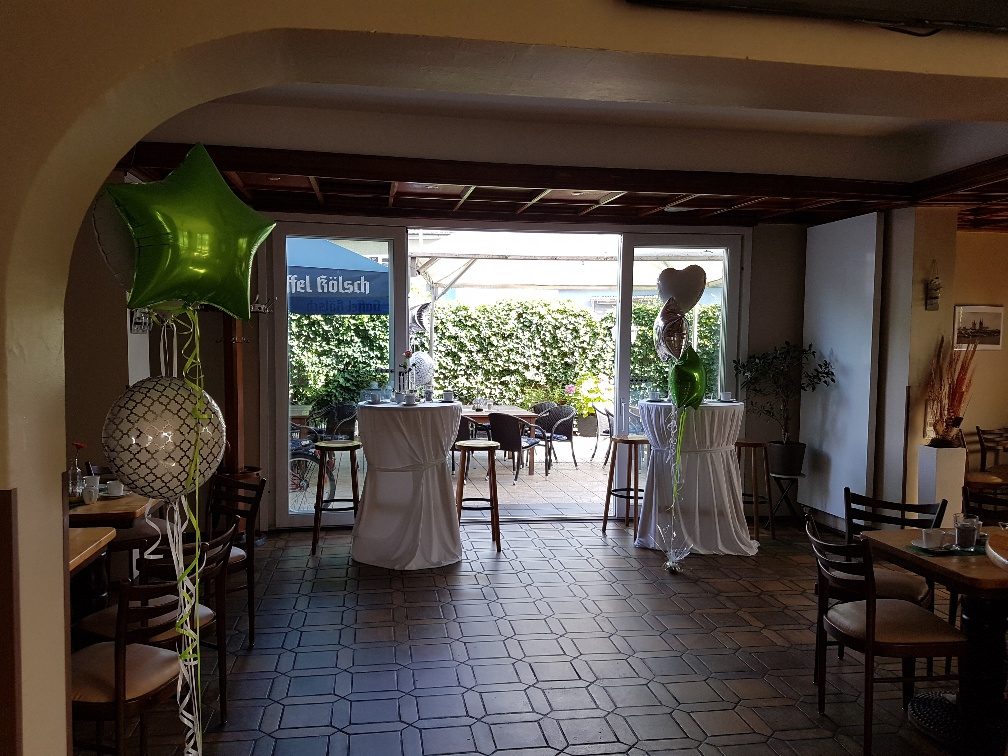 Ein Raum mit Tischen und Stühlen und Luftballons darin