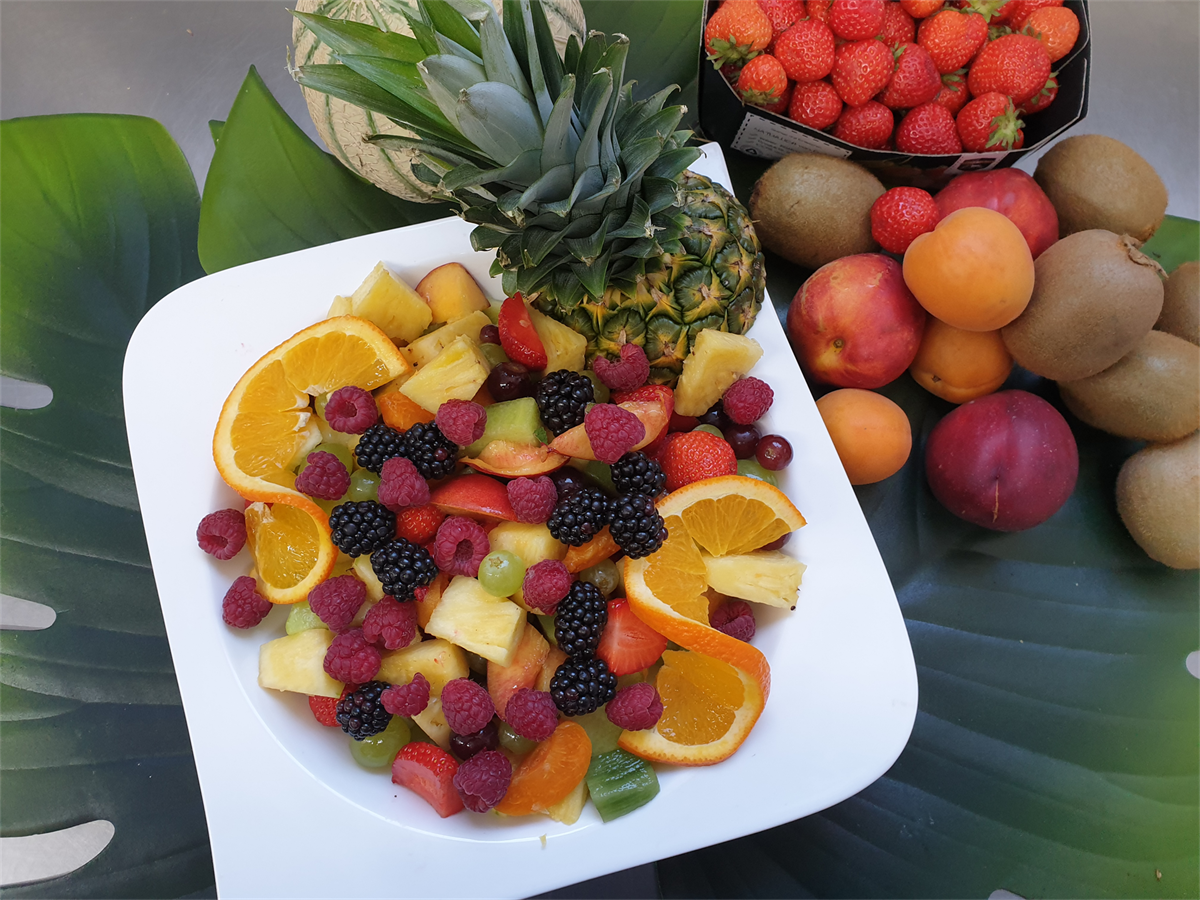 Eine Schüssel Obstsalat mit einer Ananas obendrauf