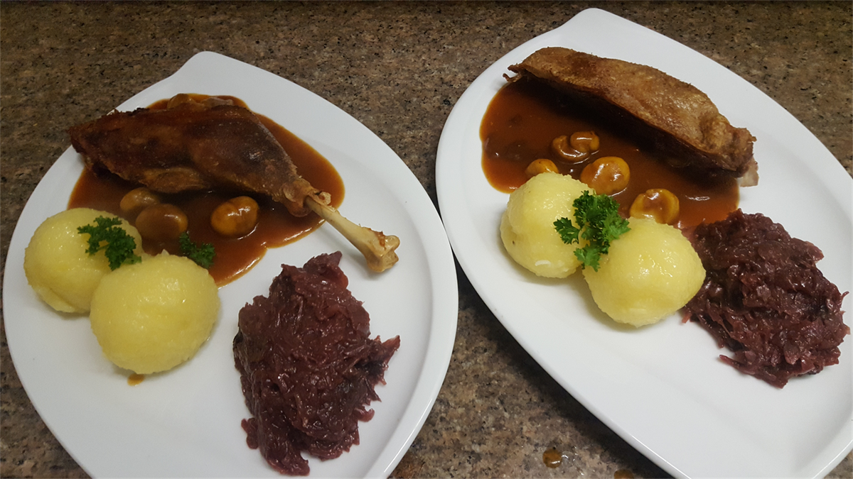 Zwei Teller mit Essen mit Kartoffeln und Soße auf einem Tisch